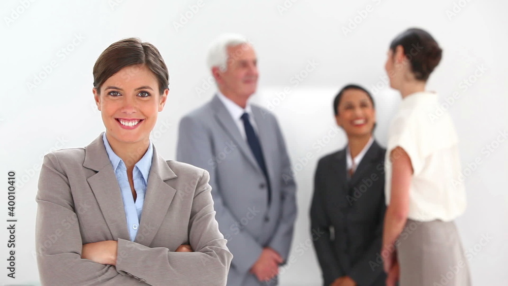 Businesswoman posing with colleagues talking Businesswoman posing with colleagues talking