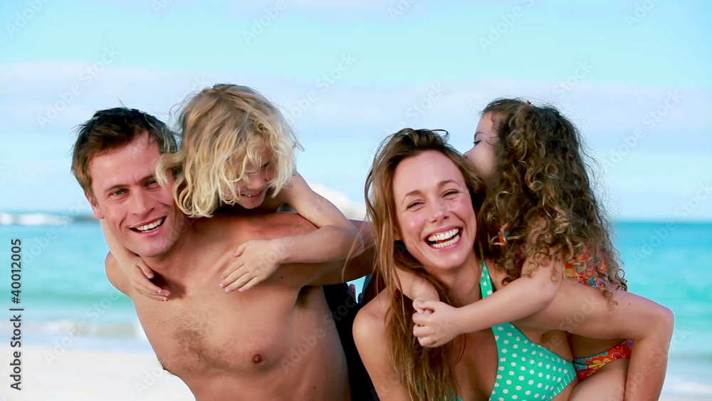 Happy parents giving their children a piggy-back Happy parents giving their children a piggy-back