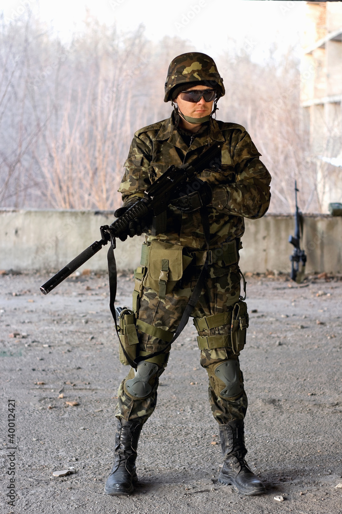 Fototapeta premium Military guy holding a gun