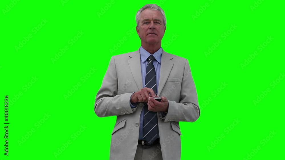 Businessman looking around while typing on his phone Businessman looking around while typing on his phone