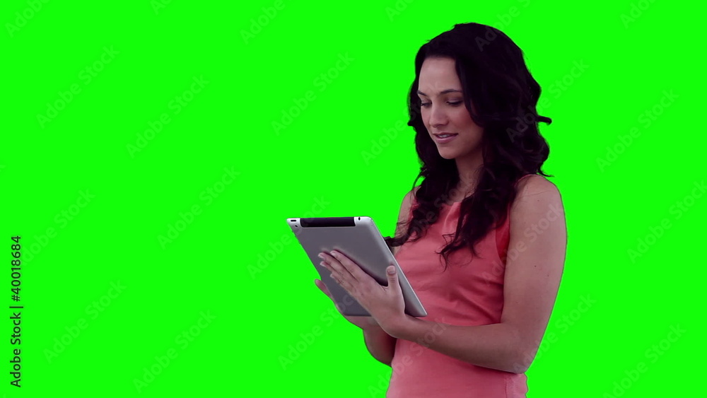 Woman smiling as she uses a tablet computer