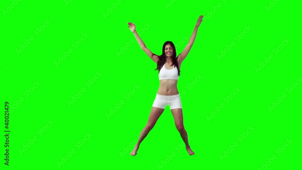 A woman is doing star jumps A woman is doing star jumps