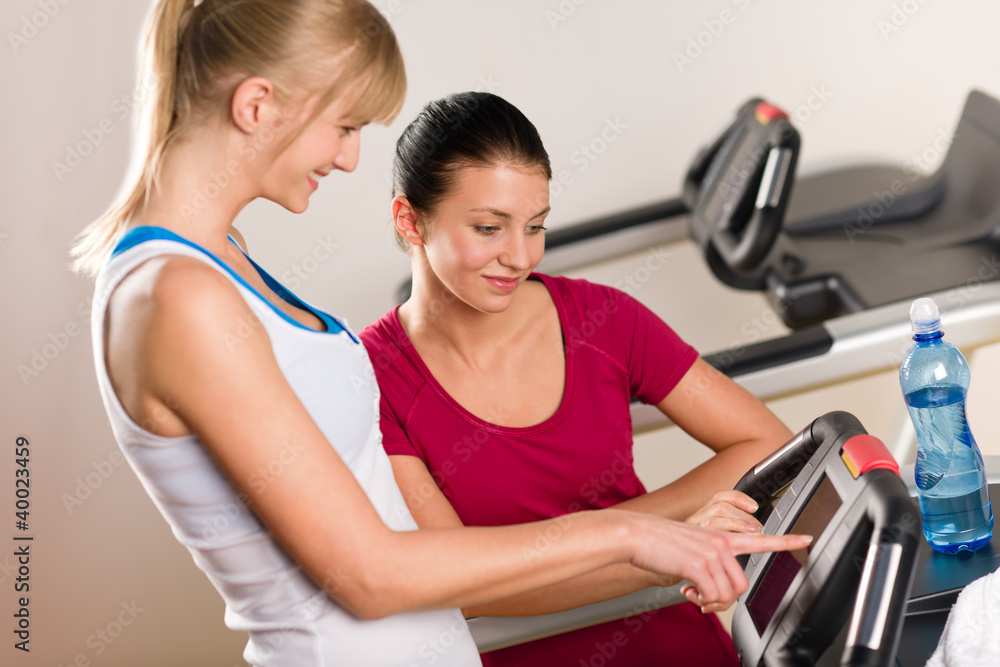 Young female friends chatting in fitness center Young female friends chatting in fitness center