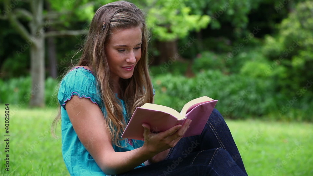 Smiling woman reading a fascinating novel Smiling woman reading a fascinating novel