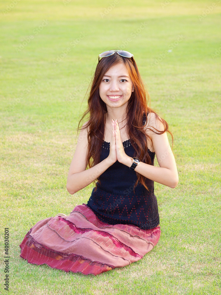 a portrait of attractive asian woman greeting on green grass fie a portrait of attractive asian woman greeting on green grass fie