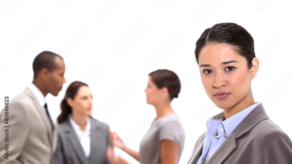 Businesswoman standing with co-workers behind her Businesswoman standing with co-workers behind her