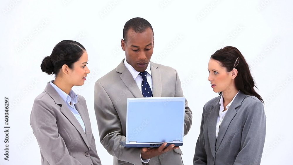 Man holding a laptop while talking with colleagues Man holding a laptop while talking with colleagues