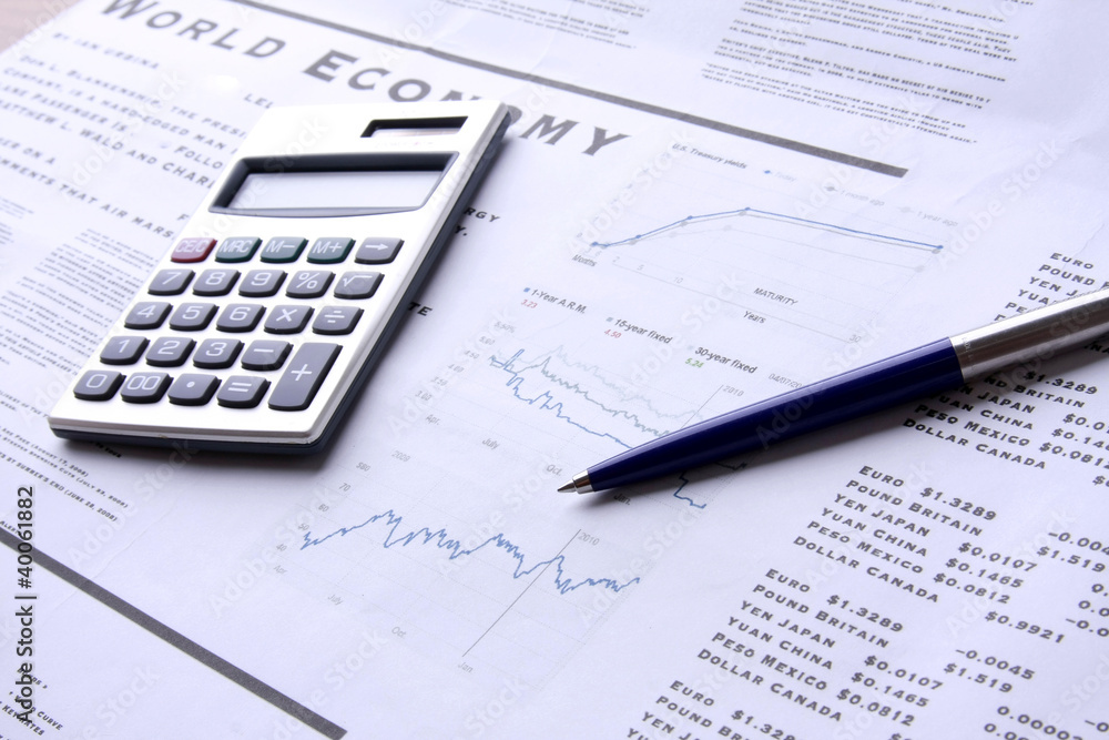 A calculator and a pen over documents, closeup A calculator and a pen over documents, closeup