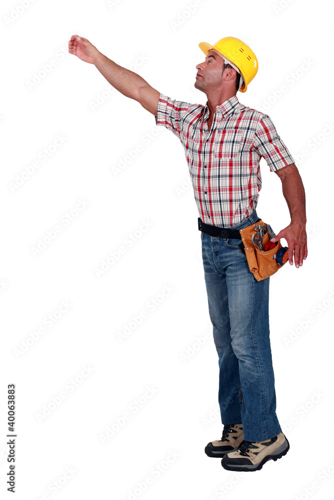 A construction worker trying to reach for something. A construction worker trying to reach for something.