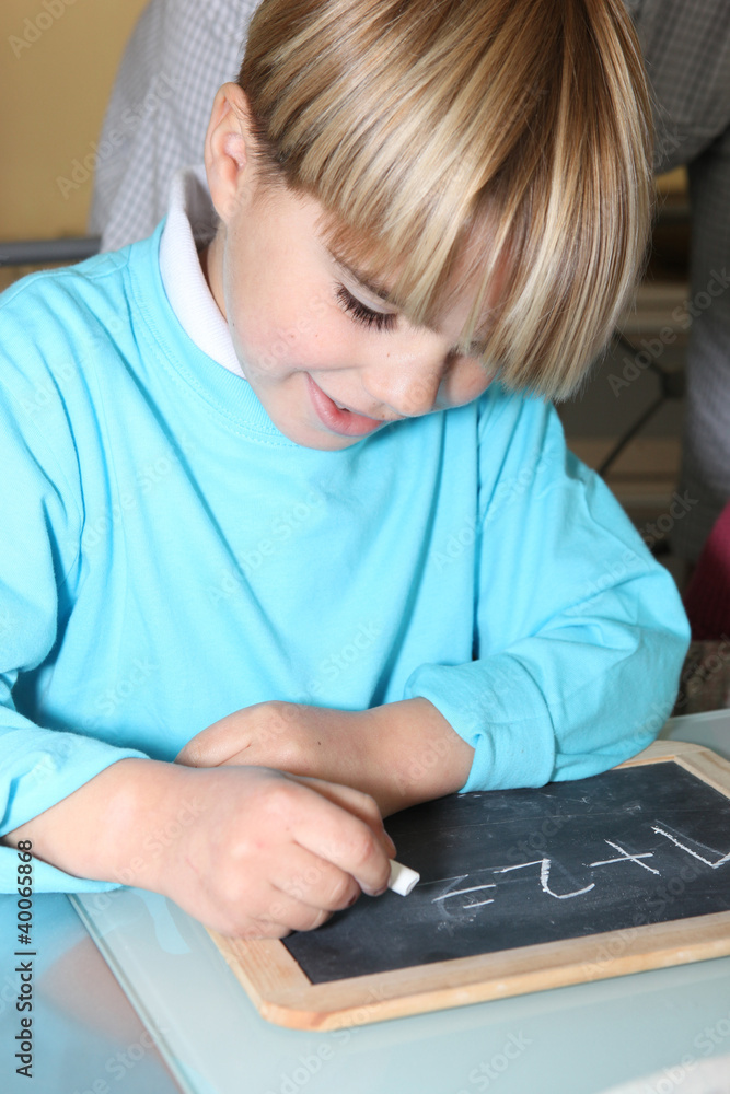 Little boy writing on a slate Little boy writing on a slate