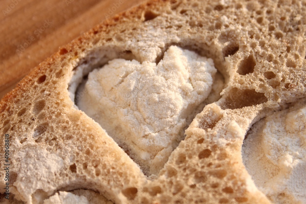 Herz aus Brot ausgestochen und mit Mehl gefüllt Herz aus Brot ausgestochen und mit Mehl gefüllt