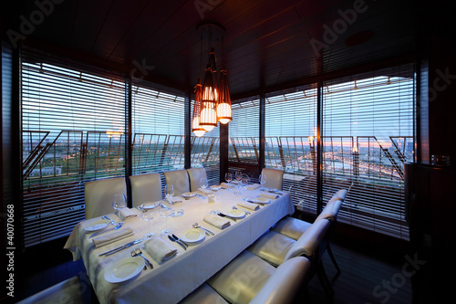 table with tablecloth and serving and chairs in restaurant photo