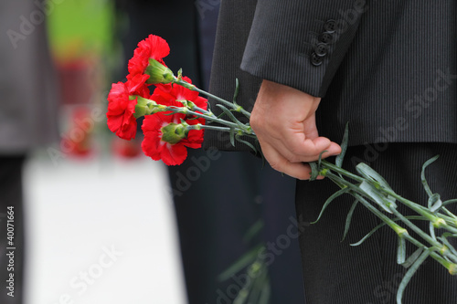 Photography Bouquet of red carnations in man hand at Victory Day celebration