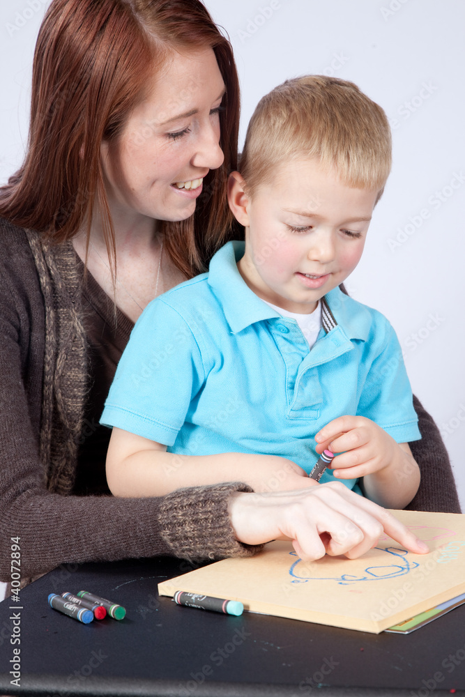 Mother and her happy blond son drawing together Mother and her happy blond son drawing together