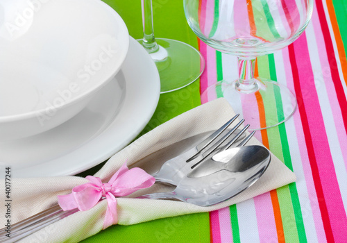 Table setting with fork, spoon, knife, plates, and napkin