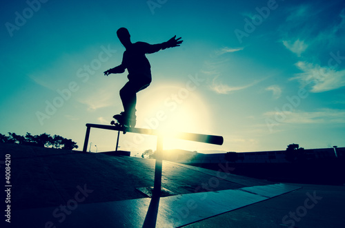Skateboarder silhouette on a grind #40084210