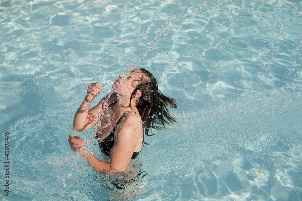 girl in a swimming pool throwing wet hair