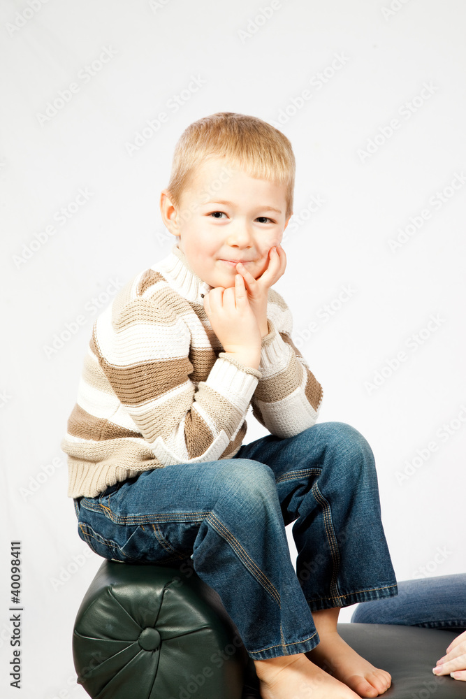 blond boy sitting on a bench smiling at the camera blond boy sitting on a bench smiling at the camera
