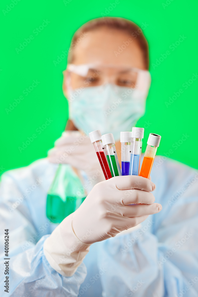 Medical test tubes with fluid sample in doctor's hand on green b Medical test tubes with fluid sample in doctor's hand on green b