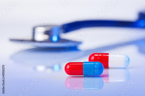 Multicolored capsules (bolus) macro still life on blue with stet photo