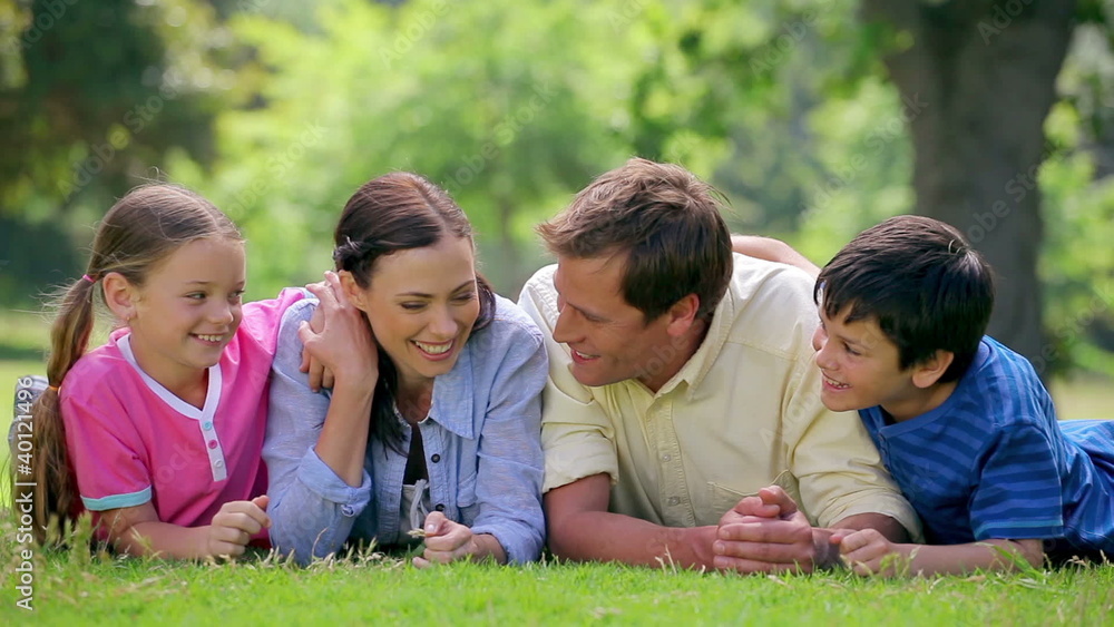 Happy family lying together on the grass Happy family lying together on the grass