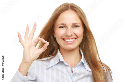 A smiling woman shows sign okay on white