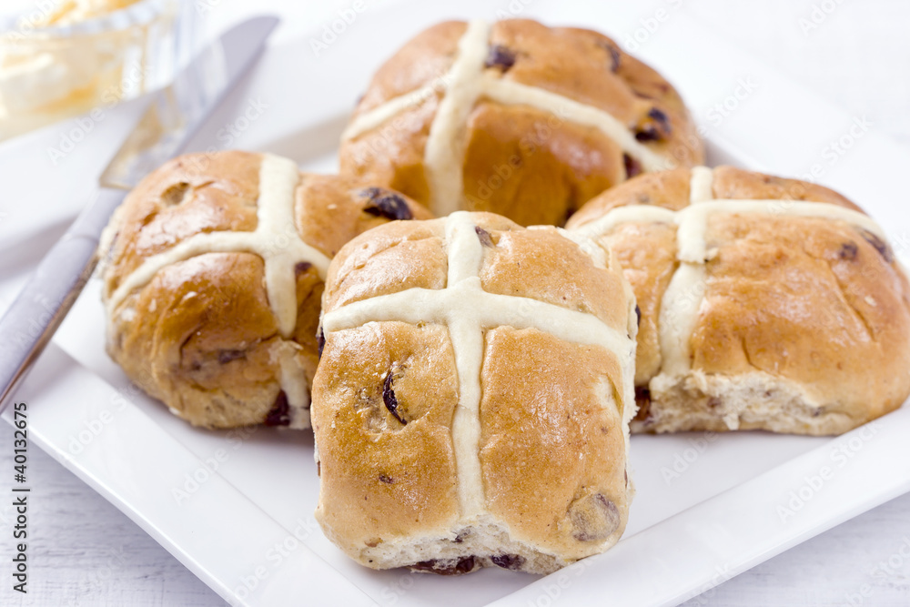 Sticky hot cross buns with rasins on white plate. Sticky hot cross buns with rasins on white plate.
