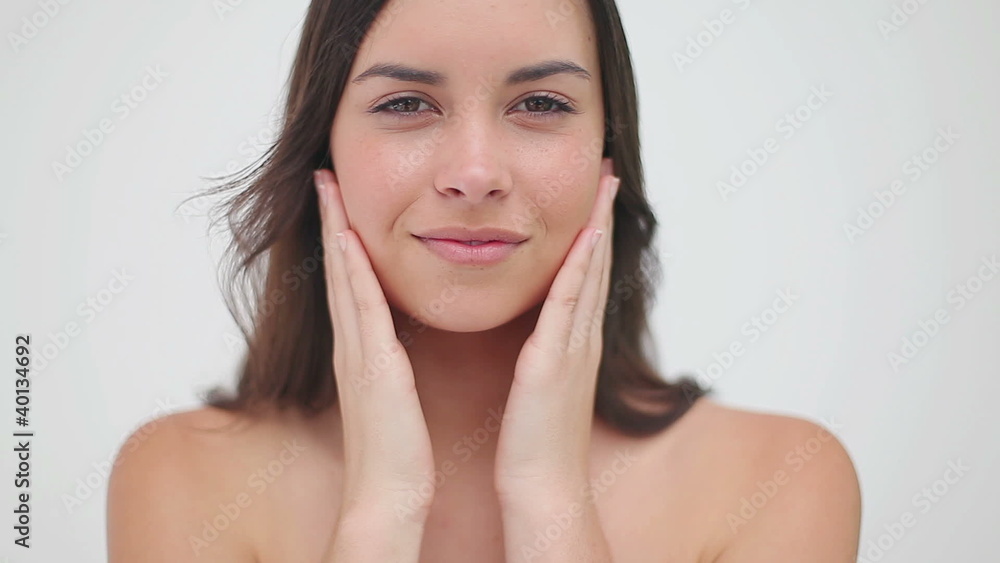 Smiling woman massaging her two cheeks