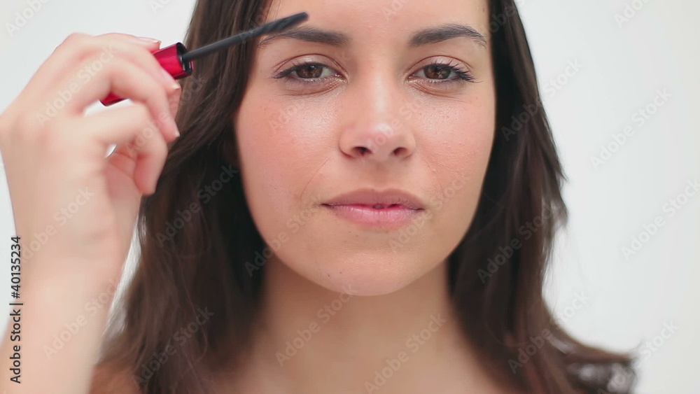 Happy brunette woman using mascara Happy brunette woman using mascara