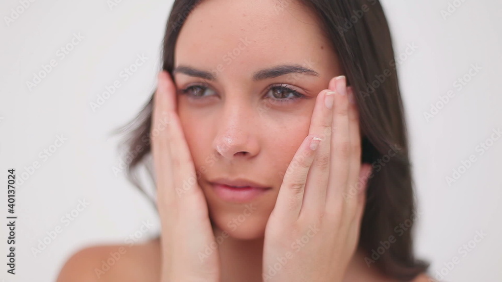 Peaceful brunette woman massaging her cheeks Peaceful brunette woman massaging her cheeks