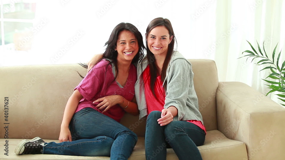 Happy women running then sitting on a couch Happy women running then sitting on a couch