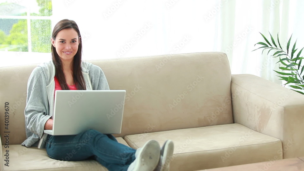 Smiling brunette woman using her personal computer Smiling brunette woman using her personal computer