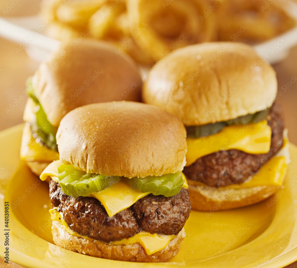 three burger sliders with cheese and pickle