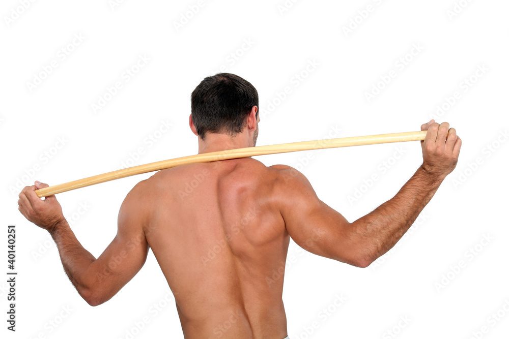 Man stretching with wooden pole Man stretching with wooden pole