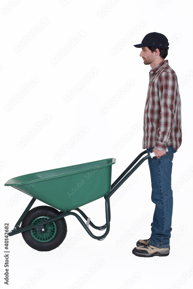 Profile shot of man stood with wheelbarrow Profile shot of man stood with wheelbarrow