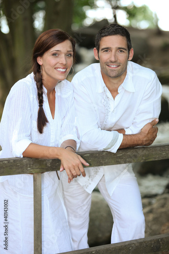Photography Couple in white leaning on a country fence