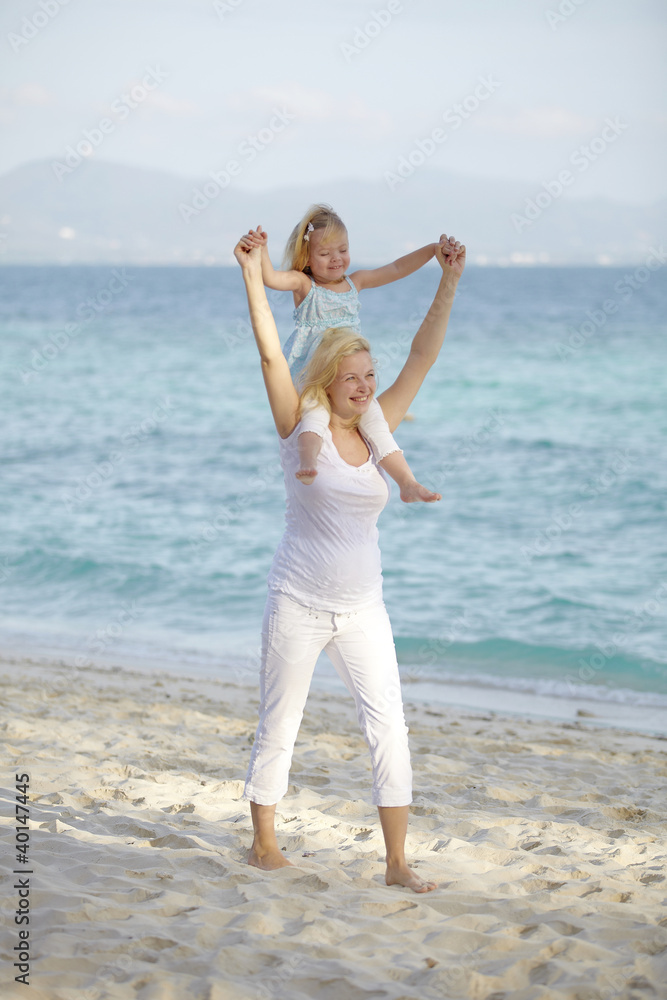 junge schwangere mutter mit ihrer tochter am strand junge schwangere mutter mit ihrer tochter am strand