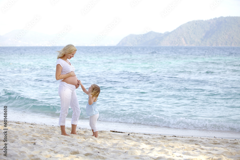 junge schwangere mutter mit ihrer tochter am strand