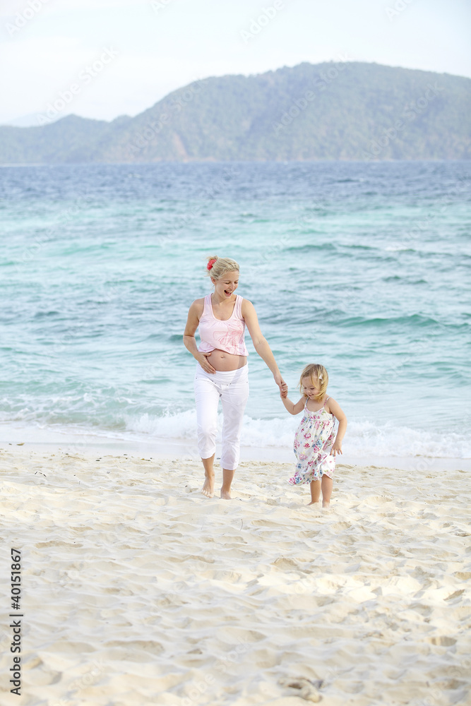 junge schwangere mutter mit ihrer tochter am strand