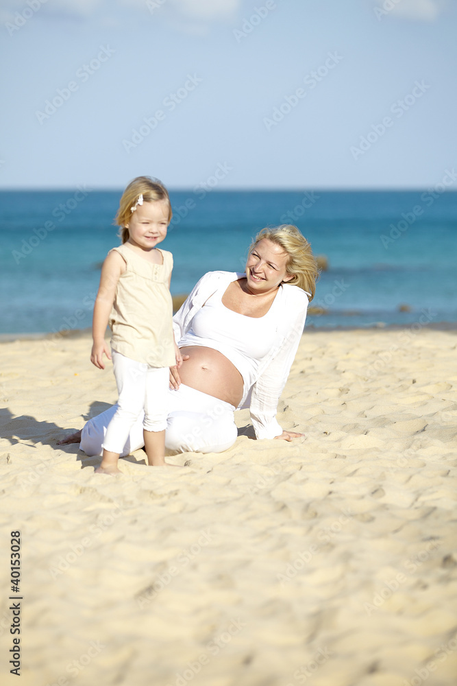junge schwangere mutter mit ihrer tochter am strand junge schwangere mutter mit ihrer tochter am strand