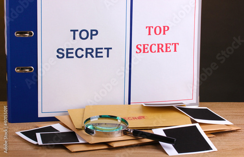 Envelopes and folders with top secret stamp and magnifying photo