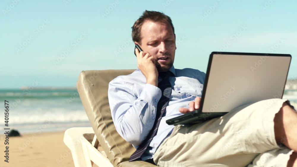 Businessman talking on cellphone and working on laptop, outdoors Businessman talking on cellphone and working on laptop, outdoors