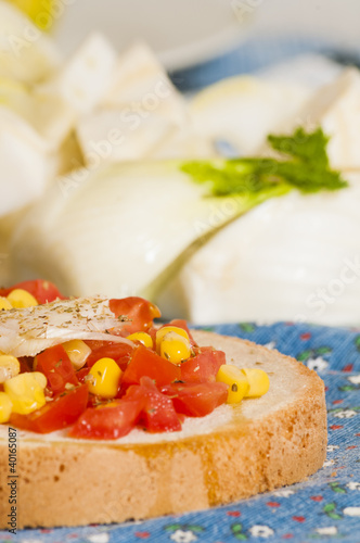 bruschetta with tomato, onion and corn on blue tablecloth