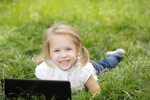Little girl on the grass with laptop © paffy