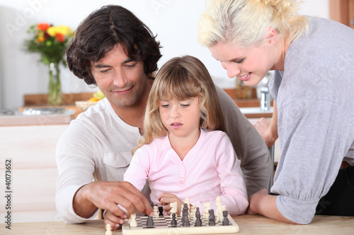 Young family playing chess