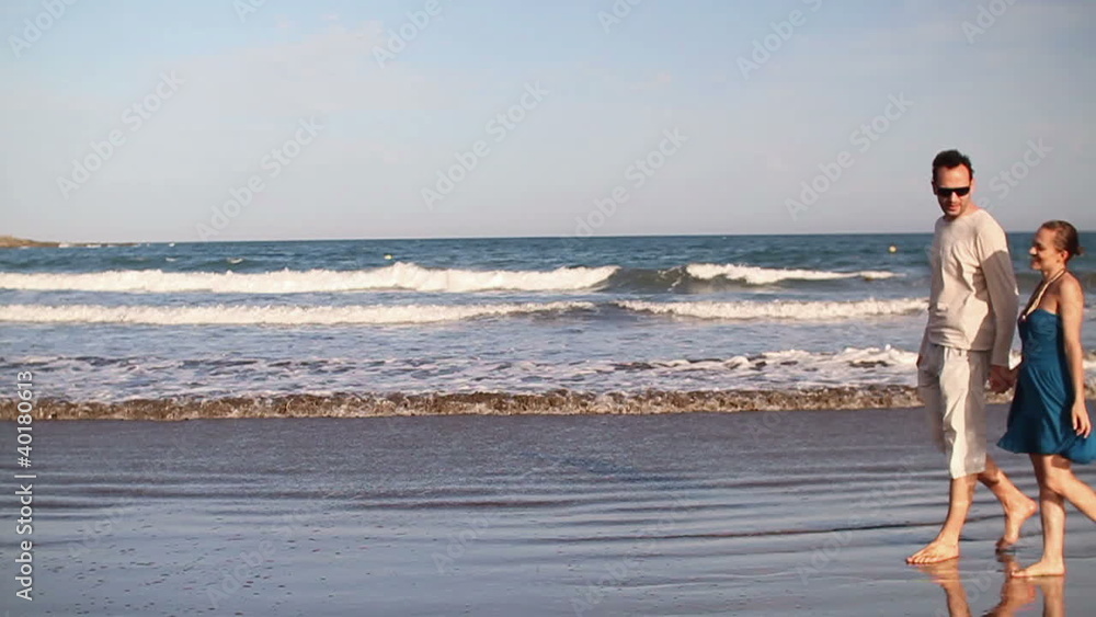 Happy couple walking on the beach, slow motion Happy couple walking on the beach, slow motion