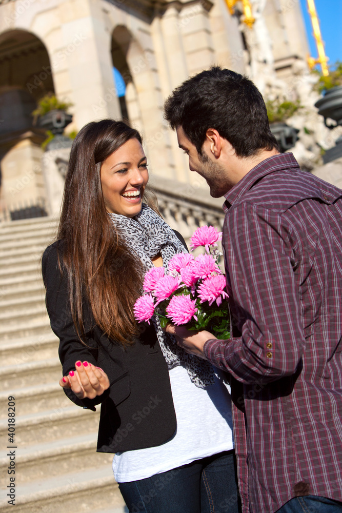 Fototapeta premium Boy surprising his girlfriend with flowers