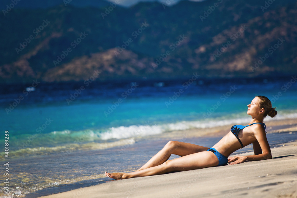 Bright photo of a beautiful model relaxing on a beach Bright photo of a beautiful model relaxing on a beach