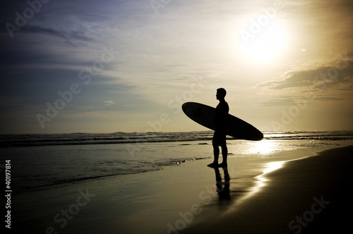 Surfer steht am Strand photo