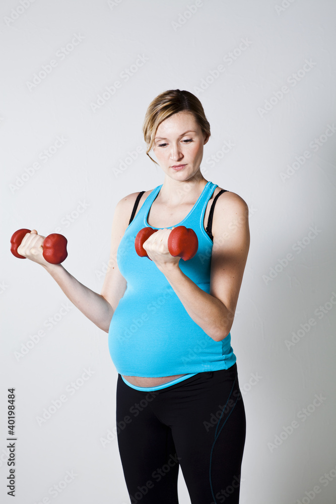 Pregnant woman exercising with dumbbells Pregnant woman exercising with dumbbells